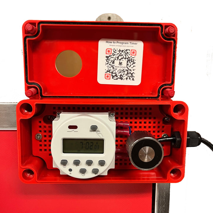 Red automatic nest box opener with timer from HenGear, featuring a clear digital display and a programming sticker.