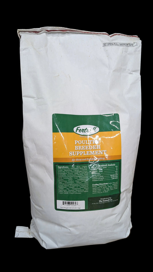a small white feed bag on a rustic table near a breeder pen of chickens, this is showcasing the feed bag for sale. the feed bag should have the words breeder supplement on it.