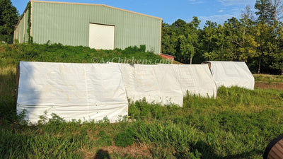 Row of pasture chicken tractors on a commercial poultry farm
