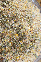 Non-GMO herbal chick starter feed blend with oregano and garlic, featuring a mix of grains and herbs, by Dahlia Pets.