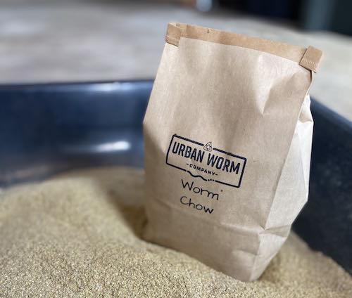 Brown protein-rich worm food in a 2lb bag from Urban Worm Company for enhancing vermicomposting.